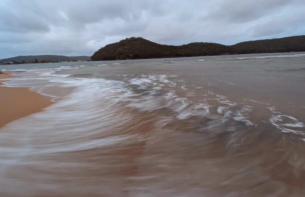 Blurred long exposure of waves washing over the sand