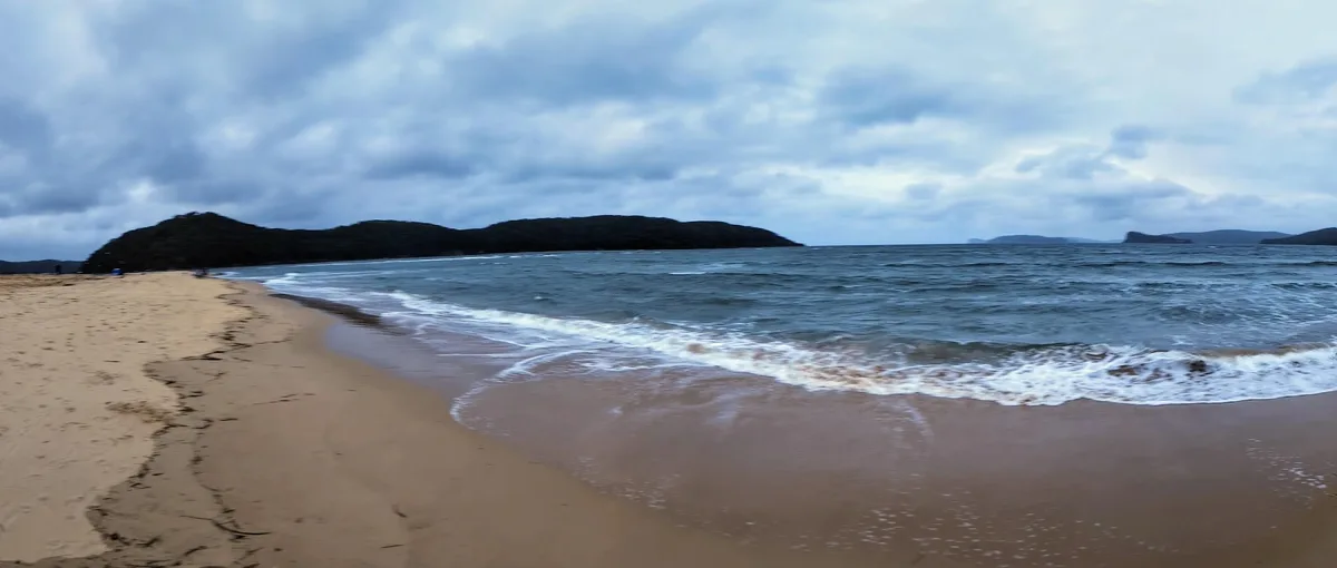 Panoramic view of the beach and headlands under a cloudy sky