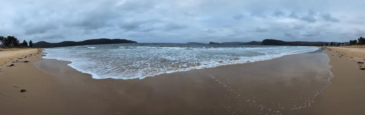 Panoramic view of the bay with headlands framing calm water