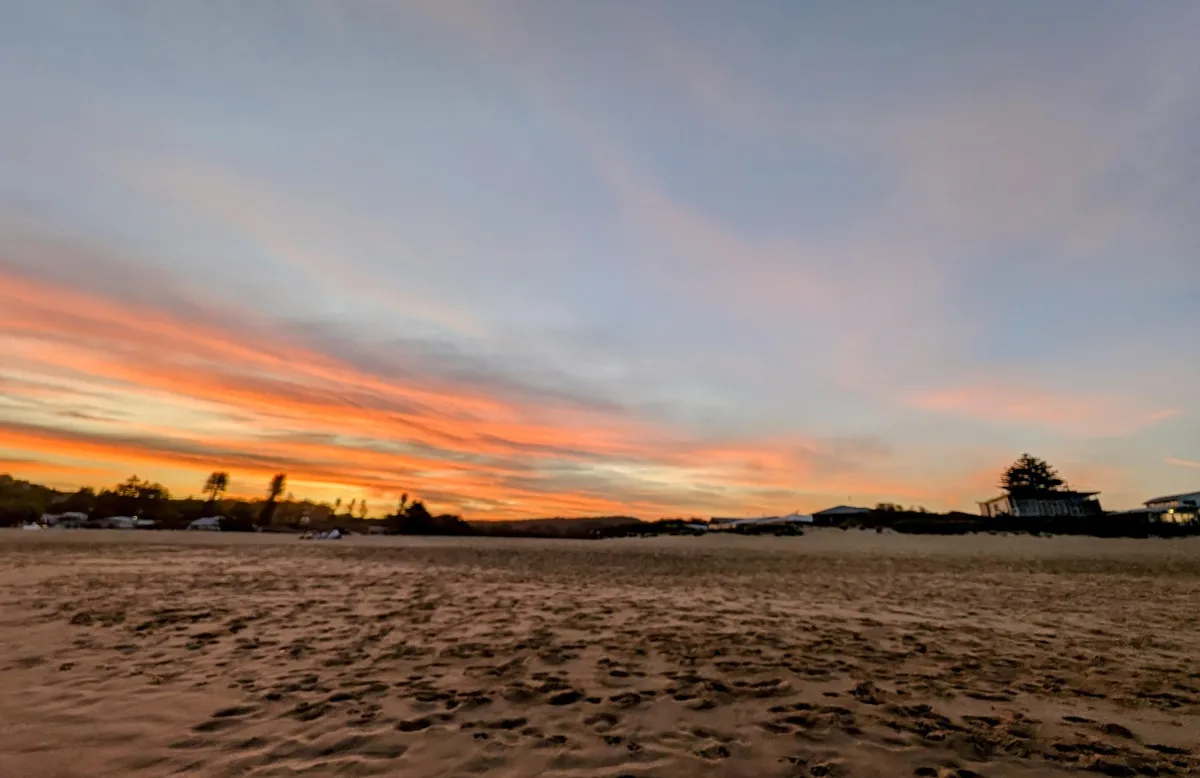 Orange sunset clouds over the sand at North Avoca beach